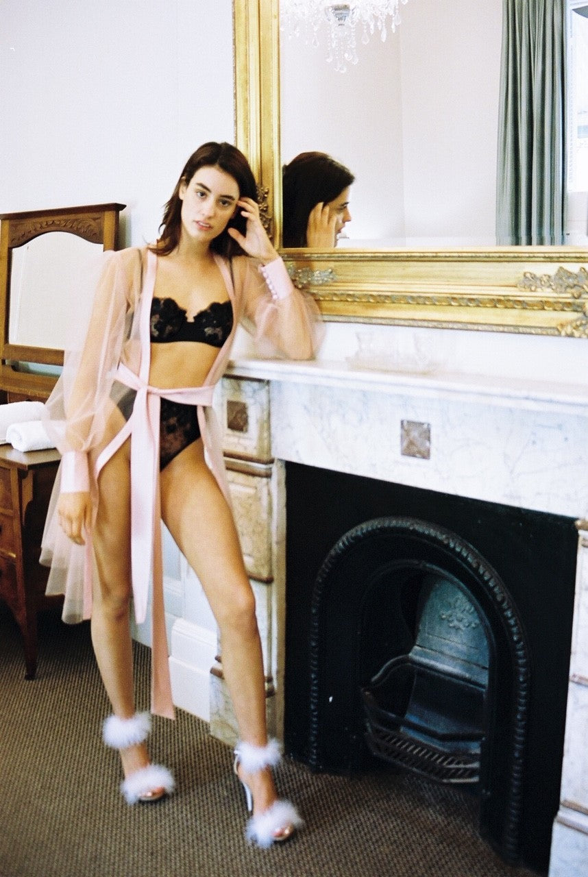 model wears blush pink sheer dressing robe with satin edges