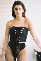 model wears black lace up corset and high waist black lace underwear 